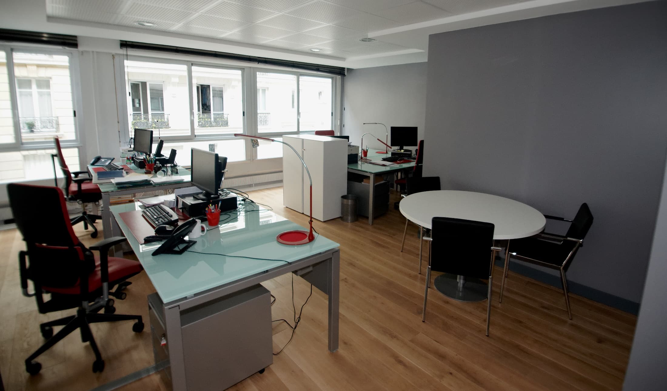 Espace de travail CGE éclairé par de grandes fenêtres.